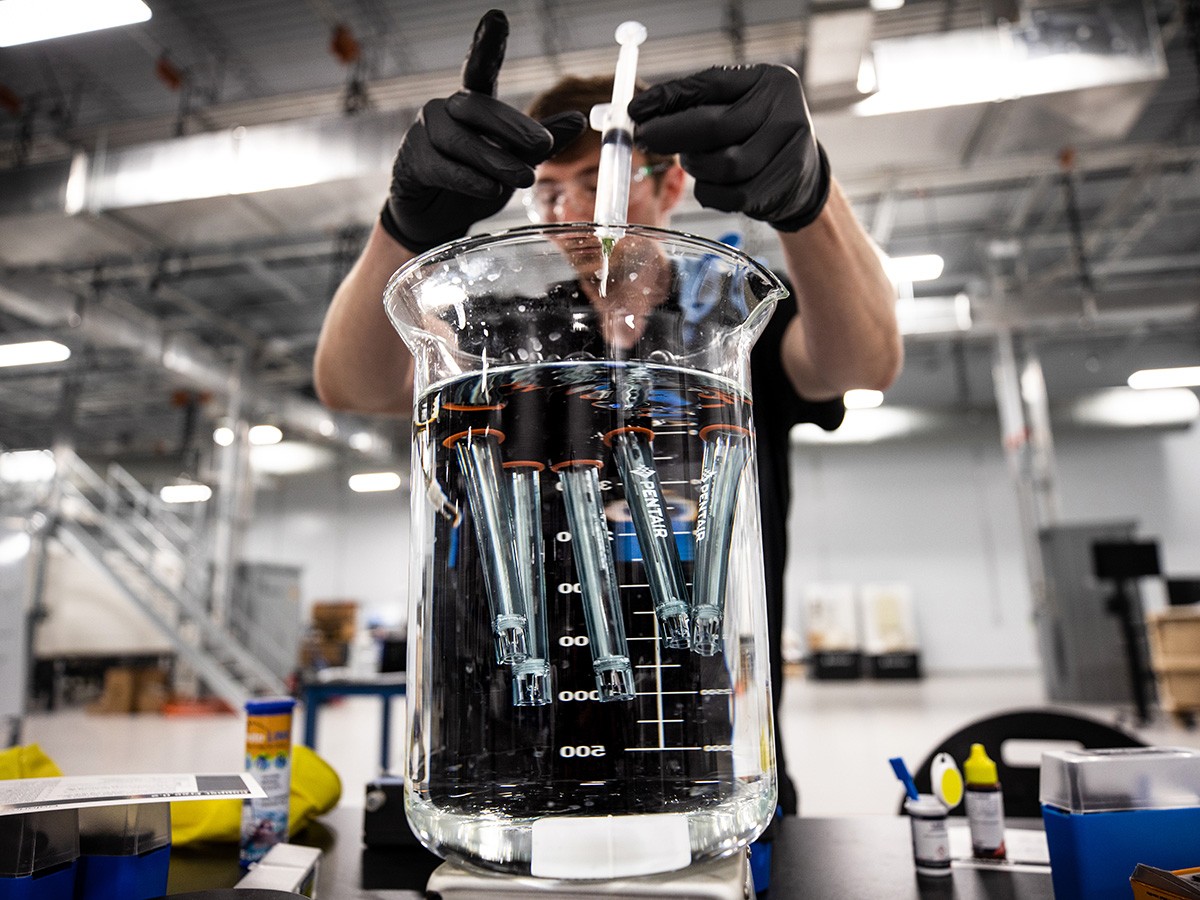 Employee testing water sensors in the Apex innovation lab