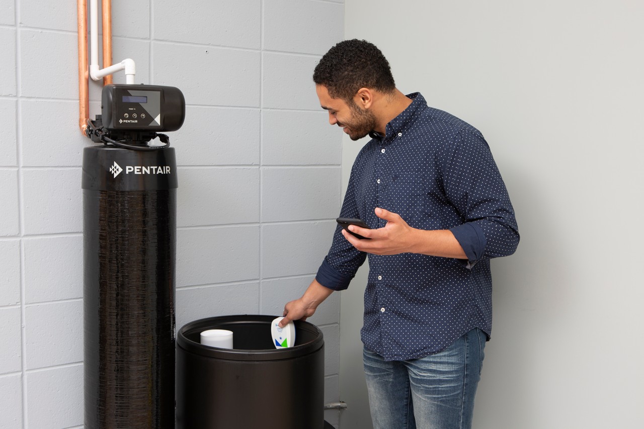 Man installing pentair connected salt sensor